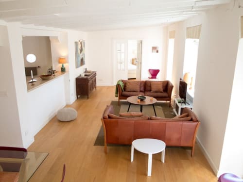 Luminosa sala de estar moderna en Top Home Integra Jerez con suelos de madera, sofá de cuero marrón y vistas a la ciudad