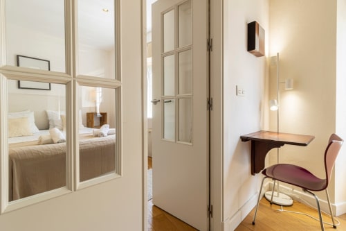 Moderno pasillo del apartamento en Top Home Integra, Jerez de la Frontera, con puertas espejadas, escritorio y vista al dormitorio