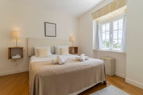 Dormitorio luminoso en apartamento Top Home Integra de Jerez de la Frontera con vistas a la ciudad, suelos de madera y decoración neutral
