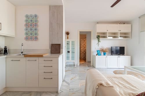 Apartamento moderno en Jerez de la Frontera con cocina, sala, dormitorio, muebles blancos y platos decorativos