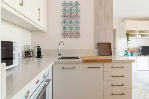 Cocina moderna con muebles crema, fregadero y azulejos decorativos azules en apartamento Top Home Integra, Jerez de la Frontera