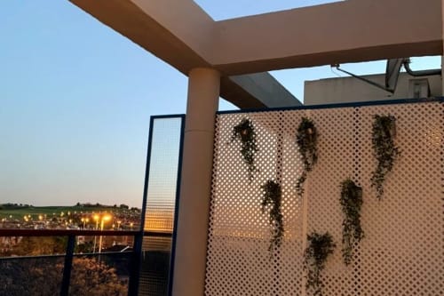 Terraza en la azotea del apartamento Top Home Integra en Jerez de la Frontera con vistas de las luces de la ciudad al atardecer