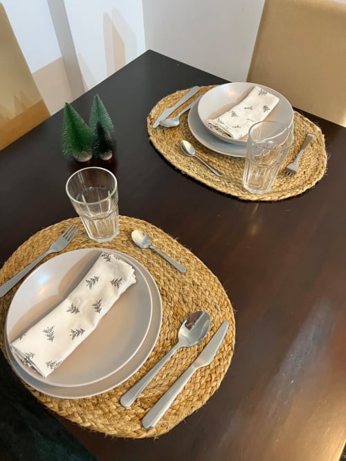 Elegante mesa servida en el apartamento Top Home Integra de Jerez con platos gourmet, individuales tejidos y decoración floral