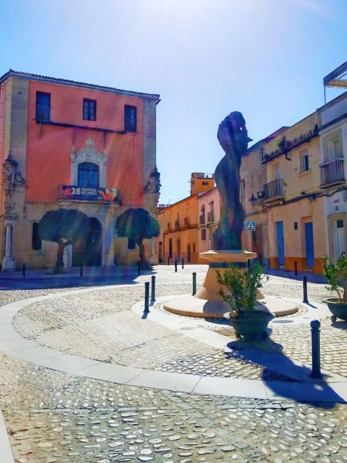 Plaza histórica colorida en Jerez de la Frontera con escultura moderna azul y arquitectura tradicional