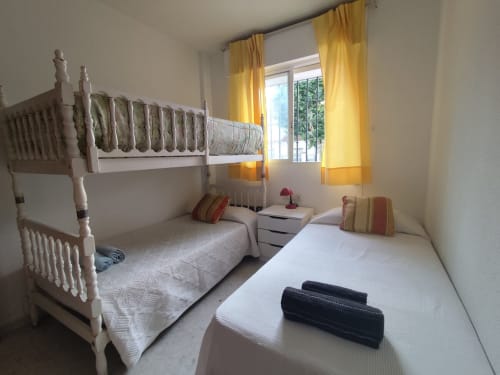 Dormitorio con camas gemelas y litera en el apartamento Top Home Integra de Jerez de la Frontera