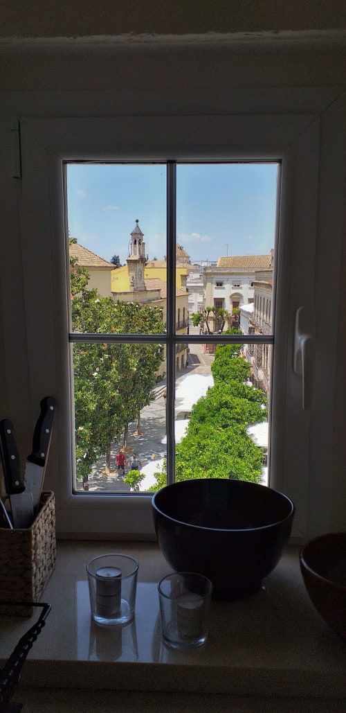 Vista desde la ventana de la cocina de la plaza histórica de Jerez de la Frontera con torre iglesia y arquitectura colonial