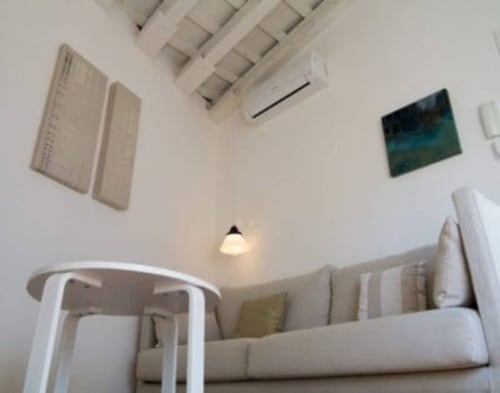 Sala de estar moderna en Top Home Integra, Jerez de la Frontera, con sofá blanco y arte contemporáneo en la pared