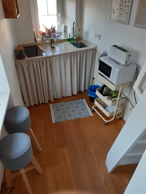 Cocina compacta en apartamento Top Home Integra, Jerez de la Frontera, con fregadero, microondas y taburetes de comedor