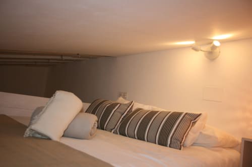 Dormitorio del apartamento Top Home Integra en Jerez de la Frontera con almohadas a rayas e iluminación moderna