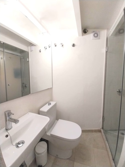 Baño moderno del apartamento Top Home Integra en Jerez de la Frontera con accesorios blancos, espejo y ducha