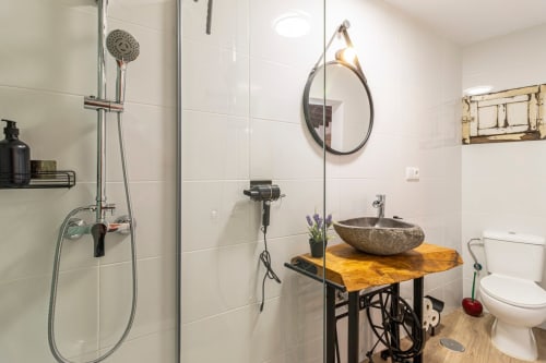 Baño moderno en Top Home Integra con ducha, lavabo de piedra y vanitory de madera en Jerez de la Frontera