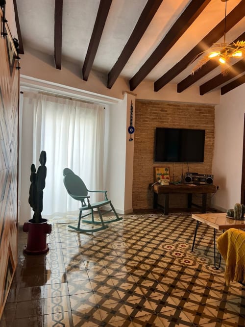 Salón moderno en Top Home Integra de Jerez de la Frontera con vigas vistas, pared de ladrillo y diseño geométrico
