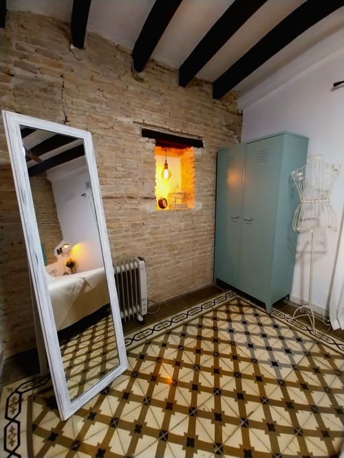 Dormitorio moderno en Top Home Integra, Jerez de la Frontera, con paredes de ladrillo, vigas vistas, espejo y toques turquesas