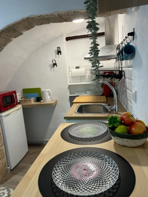 Cocina moderna en apartamento Top Home Integra, Jerez de la Frontera, con encimeras de madera, electrodomésticos blancos y detalles decorativos