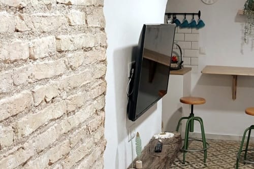 Cocina moderna del apartamento en Top Home Integra de Jerez de la Frontera con pared de ladrillo visto, TV montada y estantes de madera,