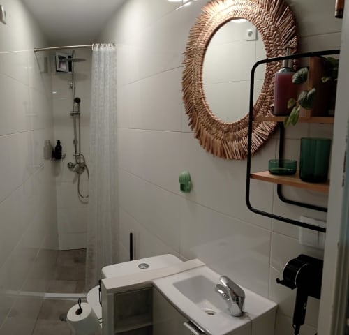 Baño moderno en apartamento Top Home Integra en Jerez de la Frontera con azulejos blancos, ducha tipo lluvia y espejo tejido