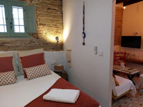 Dormitorio moderno en Top Home Integra, Jerez de la Frontera, con ladrillo visto, detalles en rojo y decoración contemporánea