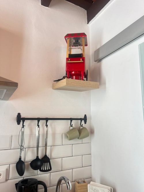 Organización de pared de cocina en Top Home Integra Jerez con máquina de palomitas roja y soporte negro de utensilios