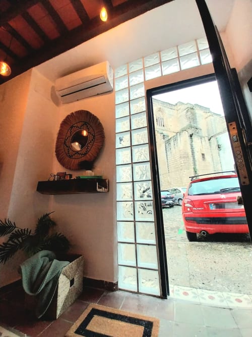 Entrada del apartamento Top Home Integra en Jerez de la Frontera con espejo decorativo de espiral, vista de la calle por ventana, coche rojo