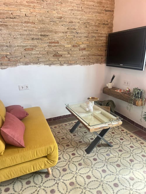 Moderno salón de apartamento en Top Home Integra en Jerez con sofá amarillo, ladrillo visto y televisor montado