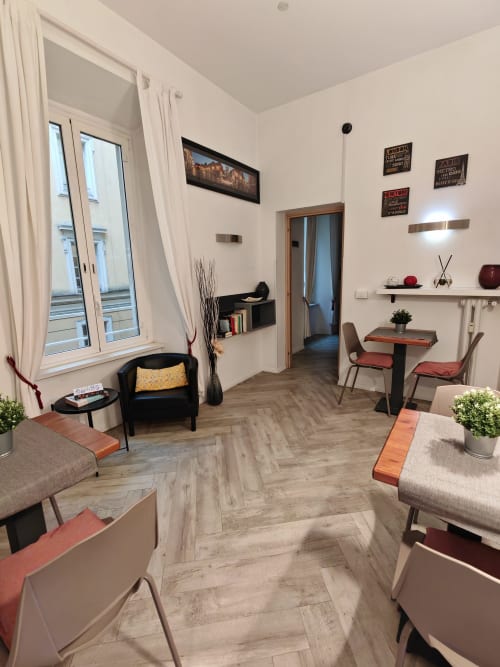 Salotto accogliente della guest house a Trastevere con posti a sedere, tavolo da pranzo e pavimento in spina di pesce