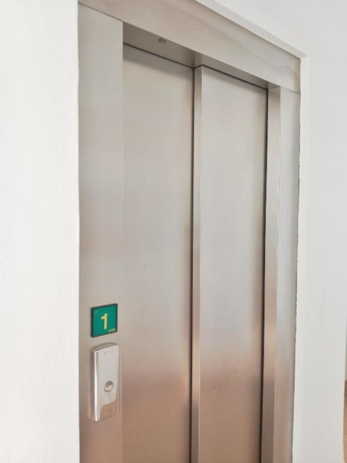Puertas de ascensor cerradas con indicador de piso mostrando 1 en Top Home Integra, aparthotel en Jerez de la Frontera