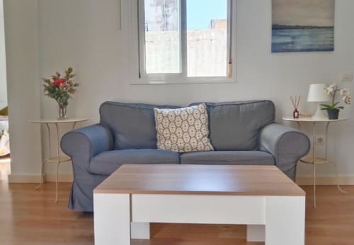 Sala moderna con sofá gris, mesa de madera y decoración costera en apartamento Top Home Integra, Jerez de la Frontera
