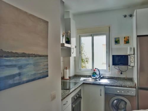 Cocina moderna en apartamento Top Home Integra, Jerez de la Frontera con electrodomésticos y arte costero