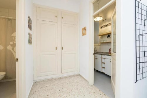 Pasillo de apartamento en Top Home Integra en Jerez de la Frontera con armarios blancos, cocina y acceso al baño