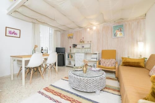 Luminosa sala de estar en Top Home Integra Jerez con muebles modernos, mesa redonda y detalles en amarillo
