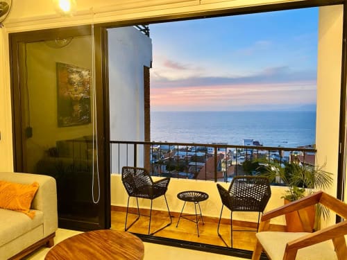 Anita Ocean View loft balcony overlooking Puerto Vallarta's Pacific Ocean at sunset with modern seating
