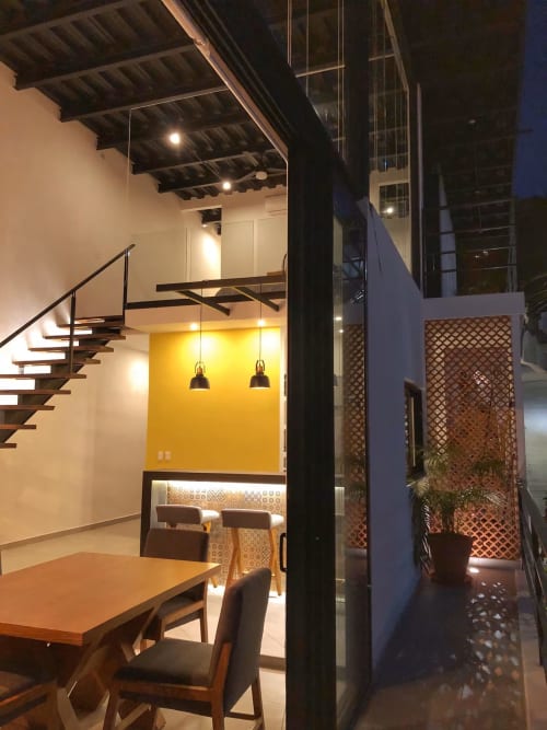 Modern loft at Anita Ocean View with yellow accent wall, dining area, floating stairs, and courtyard access in Puerto