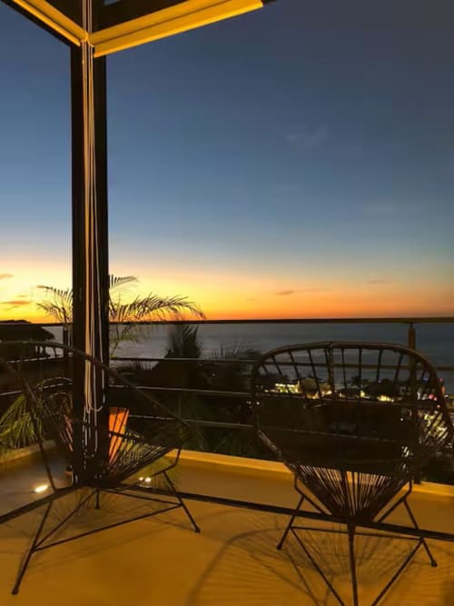 Sunset view from Anita Ocean View loft balcony in Puerto Vallarta with modern seating overlooking the sea