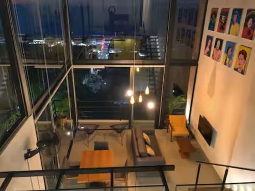 Modern loft at Anita Ocean View Puerto Vallarta with ocean view balcony, pendant lighting, and colorful wall art