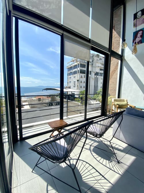 Modern loft balcony at Anita Ocean View in Puerto Vallarta with ocean views, contemporary seating, and coastal city buildings