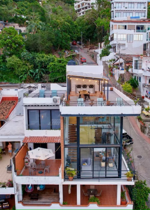 CUBO apartment at Anita Ocean View, Puerto Vallarta with modern balcony, ocean views, and lush hillside surroundings