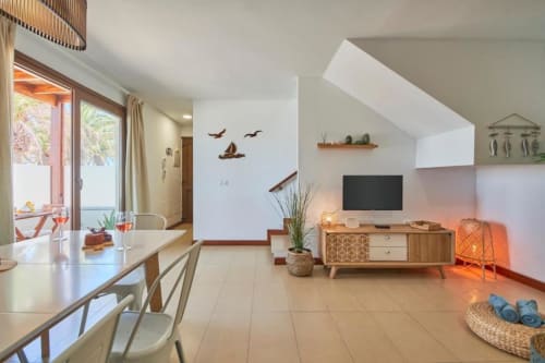 Moderno apartamento en Villa Cavendish, Playa Blanca, con sala abierta, TV, muebles de madera y balcón con vistas al jardín