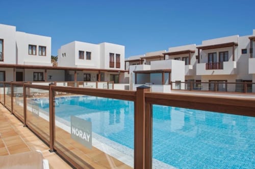 Apartamentos Villa Cavendish frente a la piscina en Playa Blanca con arquitectura moderna blanca y piscina azul