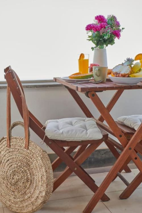 Balcón de madera en Villa Cavendish con flores coloridas, frutas frescas y vista al océano en Playa Blanca