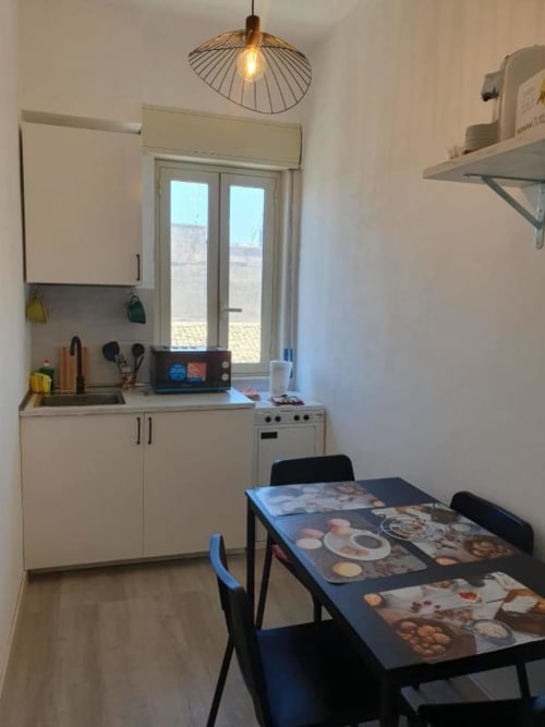Cucina moderna e zona pranzo nell'appartamento di Siracusa con vista sulla città, angolo cottura attrezzato e tavolo da pranzo