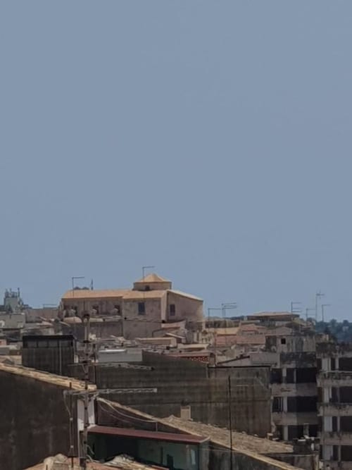 Vista della città dal balcone di Siracusa Sun&Home con tetti in terracotta e edifici storici di Siracusa, Italia