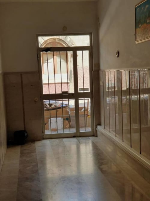 Luminoso corridoio con porte in vetro che si aprono su balcone con vista sulla città a Siracusa