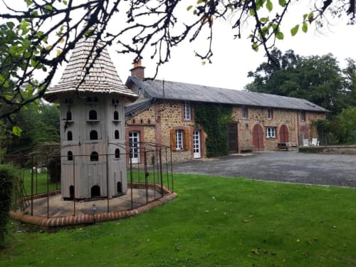 Charming stone cottage with white dovecote tower at Le Petit Lustucru B&B in Avranches, France, set in lush gardens