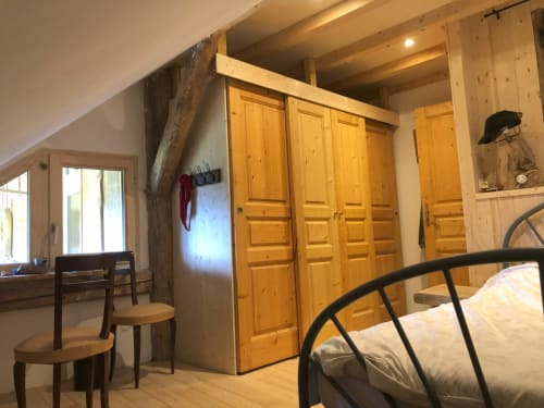 Spacieuse chambre du cottage Les Chalets de l'Eau Rousse avec meubles en bois, grands placards et vue sur les montagnes à Celliers