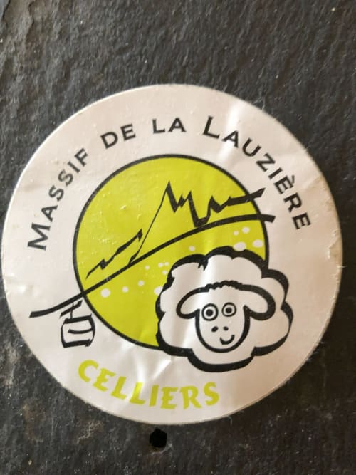 Logo vintage du Massif de la Lauzière pour la région Celliers, avec moutons sur fond de montagnes jaunes