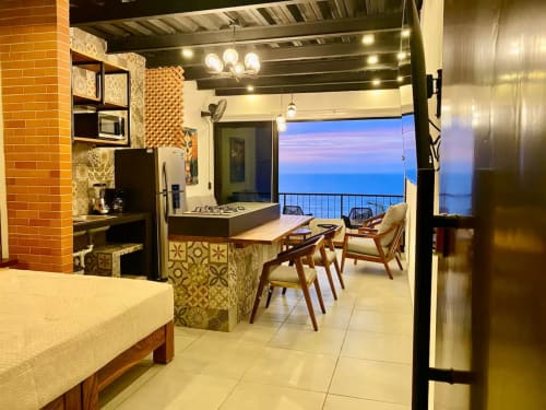 Modern CUBO apartment at Anita Ocean View, Puerto Vallarta, featuring kitchen, dining area, and ocean view balcony at dusk