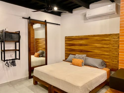 Modern bedroom at Anita Ocean View in Puerto Vallarta featuring wooden bed frame, white bedding, AC unit, and barn door