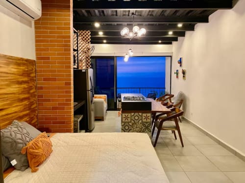 Modern CUBO apartment at Anita Ocean View Puerto Vallarta with sea view balcony, brick accent wall, and contemporary