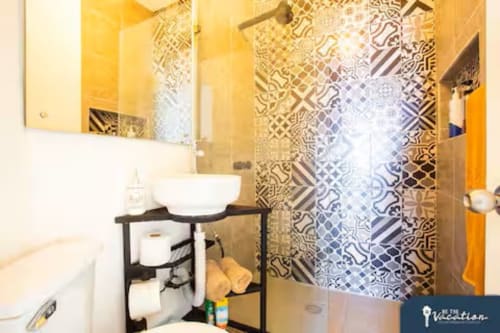 Modern bathroom in Burbuja apartment at Anita Ocean View, Puerto Vallarta with decorative tile shower and vanity sink