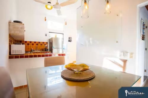 Modern kitchen and dining area in Burbuja apartment at Anita Ocean View, Puerto Vallarta with orange tile backsplash and sea